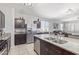 Open-concept kitchen featuring stainless steel appliances, granite counters, and a view of the living area at 3973 N 310Th Ln, Buckeye, AZ 85396