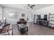 Open-concept living room with wood floors, ceiling fan, and natural light at 3973 N 310Th Ln, Buckeye, AZ 85396