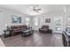 Open-concept living room with wood floors, ceiling fan, and natural light at 3973 N 310Th Ln, Buckeye, AZ 85396