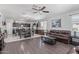 Open-concept living room with wood floors, ceiling fan, and adjacent kitchen at 3973 N 310Th Ln, Buckeye, AZ 85396