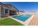 Backyard view of a refreshing pool with a waterfall feature and an outdoor dining area at 3973 N 310Th Ln, Buckeye, AZ 85396