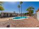 Inviting backyard with a kidney-shaped pool, mature palm trees, patio area and desert landscaping at 4154 W Grovers Ave, Glendale, AZ 85308