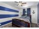 Stylish bedroom with striped walls, wood ceiling fan, and a comfortable bed at 4154 W Grovers Ave, Glendale, AZ 85308