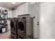 Functional laundry room with front loading washer, dryer and built in storage at 4154 W Grovers Ave, Glendale, AZ 85308