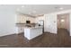 A bright kitchen is complete with an island, stainless appliances, plenty of cabinet space, and plank tile flooring at 4169 W Eli Dr, San Tan Valley, AZ 85144