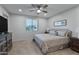 Well-lit bedroom featuring a queen-sized bed with decorative pillows and a ceiling fan at 42195 W Lavender Dr, Maricopa, AZ 85138