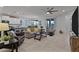 Open-concept living room with tile flooring, ceiling fan, and seamless flow into the kitchen and dining area at 42195 W Lavender Dr, Maricopa, AZ 85138