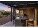 Covered patio featuring outdoor fire table and travertine tiles with desert landscaping at 42195 W Lavender Dr, Maricopa, AZ 85138