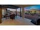 Covered patio with travertine tiles and desert landscaping with outdoor dining area and grill at 42195 W Lavender Dr, Maricopa, AZ 85138