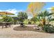 Beautifully landscaped backyard with custom pavers, rock garden, mature trees, and dining set at 42920 W Kingfisher Dr, Maricopa, AZ 85138