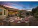 Inviting backyard with a fire pit, patio, outdoor kitchen, and lush landscaping at 42920 W Kingfisher Dr, Maricopa, AZ 85138