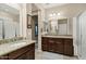 Bathroom featuring double sinks, granite counters, dark wood cabinets, and tile flooring at 42920 W Kingfisher Dr, Maricopa, AZ 85138