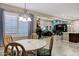 Light-filled dining area with a round table, shuttered windows and views into the living room at 42920 W Kingfisher Dr, Maricopa, AZ 85138