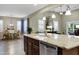 Granite kitchen island adjacent to an open concept living and dining area at 42920 W Kingfisher Dr, Maricopa, AZ 85138