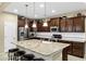 Modern kitchen featuring a center island, stainless steel appliances, and dark wood cabinetry at 42920 W Kingfisher Dr, Maricopa, AZ 85138