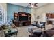 Spacious living room featuring a decorative entertainment center, comfortable seating and neutral carpet at 42920 W Kingfisher Dr, Maricopa, AZ 85138