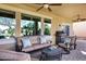 Inviting covered patio featuring a ceiling fan, grill, plush sofa, comfortable seating, and stone pavers at 42920 W Kingfisher Dr, Maricopa, AZ 85138