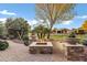 Inviting patio featuring a stone fire pit with seating and lush landscaping at 42920 W Kingfisher Dr, Maricopa, AZ 85138