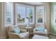 Cozy sitting area with two armchairs, a small table, and bright natural light from the windows at 42920 W Kingfisher Dr, Maricopa, AZ 85138