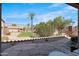 View of the backyard featuring desert landscaping, a stone tile patio, and wrought-iron fencing at 4528 W Valencia Dr, Laveen, AZ 85339