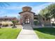 Unique arched stone entrance with wrought iron gate and lush landscaping leading to the home's entrance at 4528 W Valencia Dr, Laveen, AZ 85339