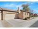 Exterior view of the home, showcasing desert landscaping, a two-car garage, and a decorative tile roof at 4528 W Valencia Dr, Laveen, AZ 85339