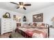 Comfortable bedroom featuring a patchwork quilt, ceiling fan, and en-suite bathroom at 468 E Wolf Hollow Dr, Casa Grande, AZ 85122