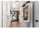 Bright entryway featuring neutral tile flooring, a decorative shelving unit, and an open door to the outside at 468 E Wolf Hollow Dr, Casa Grande, AZ 85122