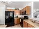 Bright kitchen featuring wood cabinets, black appliances, and neutral countertops at 468 E Wolf Hollow Dr, Casa Grande, AZ 85122