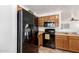 Bright kitchen featuring wood cabinets, black appliances, and neutral countertops at 468 E Wolf Hollow Dr, Casa Grande, AZ 85122