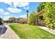 Grassy backyard featuring a pool with a fence, beautiful greenery, and a covered patio area at 4926 S Hemet St, Gilbert, AZ 85298