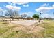 Outdoor basketball court surrounded by landscaping, benches and trees under a partly cloudy blue sky at 4926 S Hemet St, Gilbert, AZ 85298