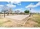 Outdoor basketball court surrounded by trees and benches under a partly cloudy blue sky at 4926 S Hemet St, Gilbert, AZ 85298