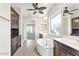 Elegant bathroom featuring a soaking tub, dual sinks, dark cabinetry, and natural light at 4926 S Hemet St, Gilbert, AZ 85298