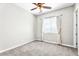 Cozy bedroom with a ceiling fan, carpet flooring, and a window bringing in natural light at 4926 S Hemet St, Gilbert, AZ 85298