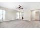 Large carpeted bedroom with ceiling fan, bright windows, and doorway to bathroom at 4926 S Hemet St, Gilbert, AZ 85298