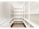 Bright walk-in pantry with adjustable white shelving and wood-look floors for organized storage at 4926 S Hemet St, Gilbert, AZ 85298