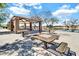 Covered picnic area with tables and benches overlooking a scenic lake, perfect for outdoor gatherings at 4926 S Hemet St, Gilbert, AZ 85298