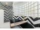 Modern bathroom with freestanding tub, gold fixtures, glass block window, and black and white chevron accent wall at 5601 E Caballo Dr, Paradise Valley, AZ 85253