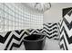 Modern bathroom features a standalone tub with glass block window and black and white chevron patterned walls at 5601 E Caballo Dr, Paradise Valley, AZ 85253