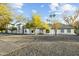 Stunning single-story white home with a circular driveway and well-manicured landscaping with mountain views at 5601 E Caballo Dr, Paradise Valley, AZ 85253