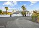 Impressive white home with brick driveway, framed by palm trees and mountain views in the background at 5601 E Caballo Dr, Paradise Valley, AZ 85253