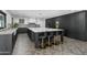 Spacious kitchen featuring a large marble island, hardwood floors, and modern black cabinetry at 5601 E Caballo Dr, Paradise Valley, AZ 85253