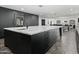 Kitchen island with marble countertop, sink, and black cabinets overlooking the open floor plan at 5601 E Caballo Dr, Paradise Valley, AZ 85253