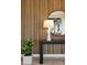 Hallway with console table, table lamp, round mirror, wood accent wall and house plant at 5711 S Quartz St, Gilbert, AZ 85298