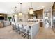 Open concept kitchen featuring a large center island with bar stool seating, stainless steel appliances, and modern lighting at 5711 S Quartz St, Gilbert, AZ 85298