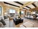 Spacious living room featuring high ceilings with wood beam accents, modern decor, and an adjacent dining area at 5711 S Quartz St, Gilbert, AZ 85298