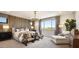 Relaxing main bedroom features a wooden accent wall, chandelier, lounge chair, and plenty of natural light at 5711 S Quartz St, Gilbert, AZ 85298