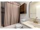 Bathroom with tub and shower, wood cabinet, and light marble countertops at 5809 E Thomas Rd, Scottsdale, AZ 85251