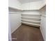 An organized closet with white shelves and bars for hanging clothes at 5809 E Thomas Rd, Scottsdale, AZ 85251